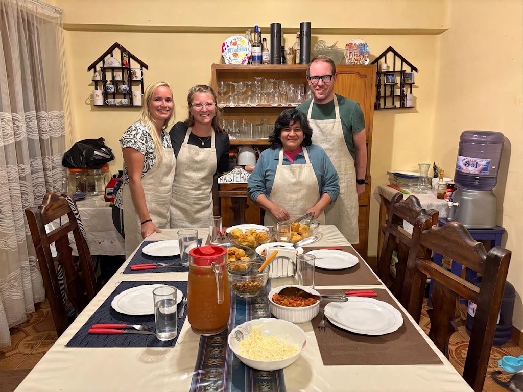 Grupo de viajeros disfrutando de una clase de cocina boliviana en familia